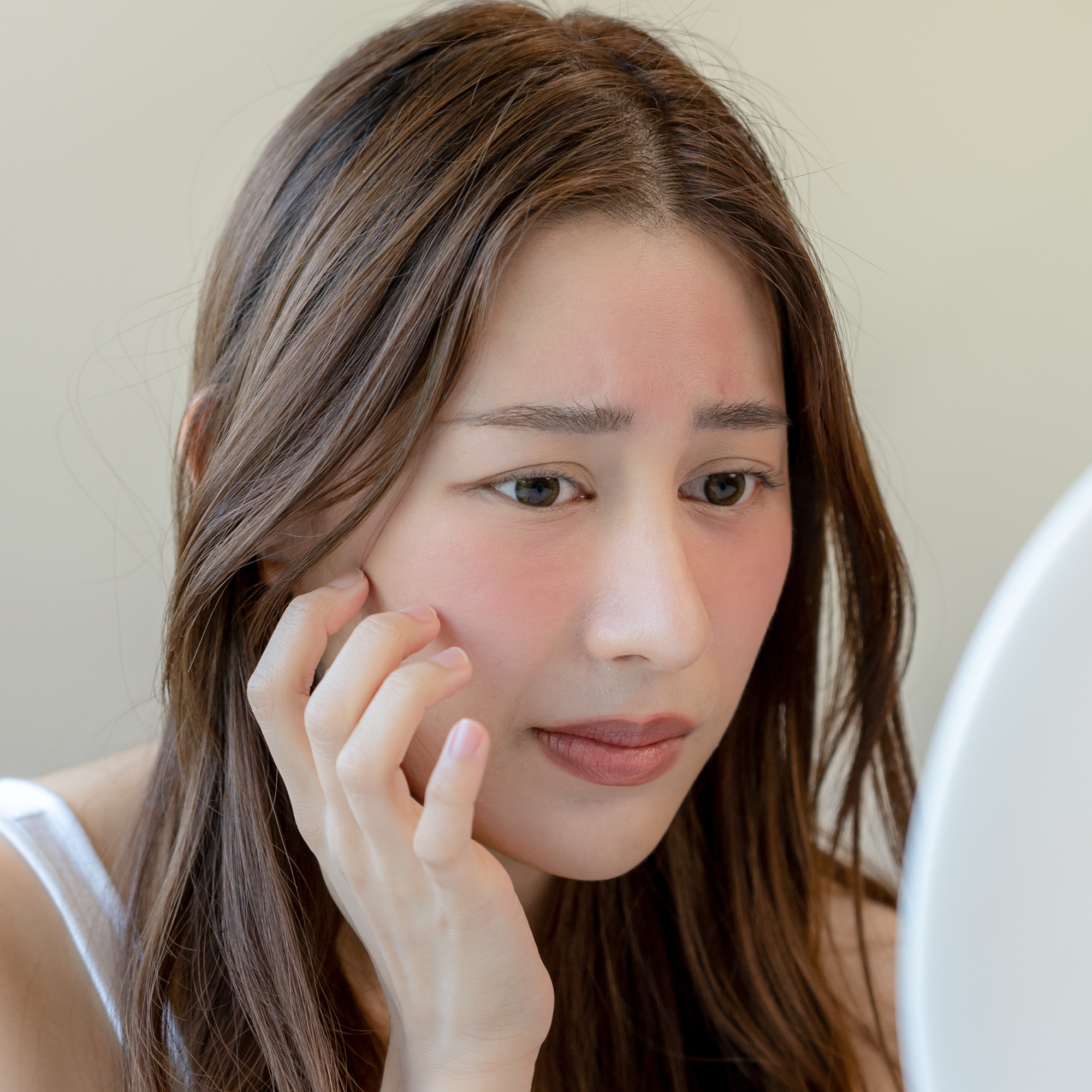 crème,gel,exfoliant étendus sur une surface avec un fond pêche mais dont certains produits causent des réactions cutanées ouallergiques