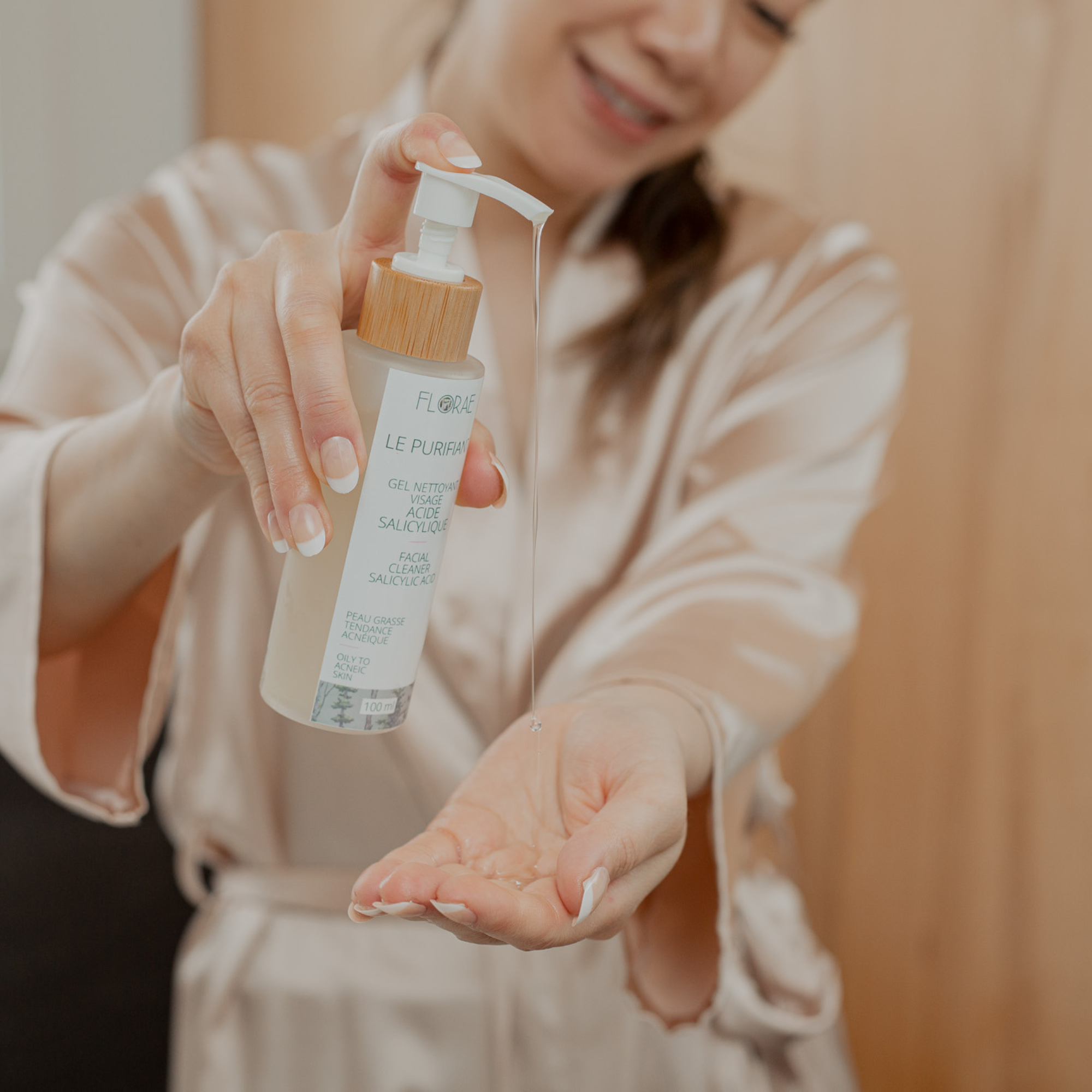 Femme en peignoir utilisant un nettoyant Florae Cosmétiques
