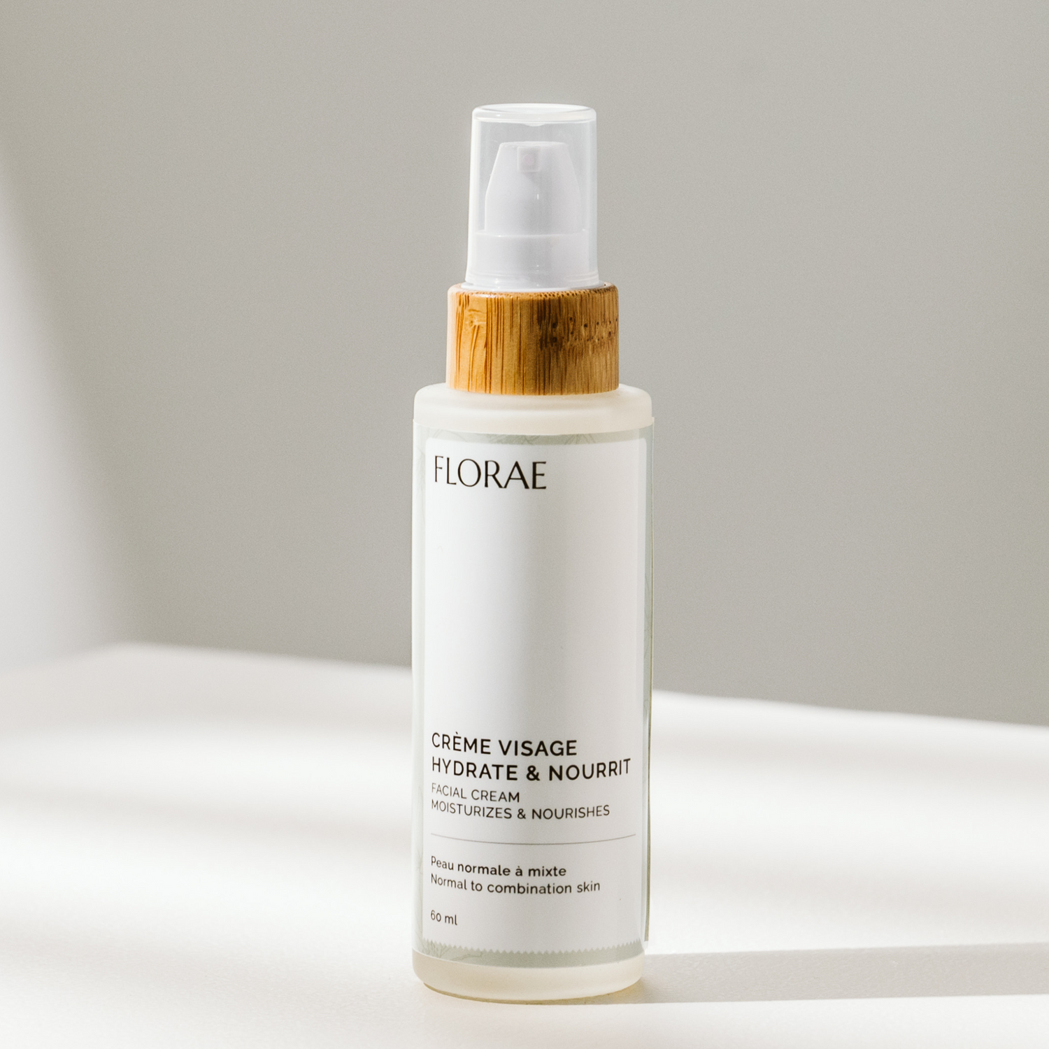 Crème hydratante naturelle de la gamme Florae cosmétique, dans un flacon de verre avec un bouchon de bambou muni d&