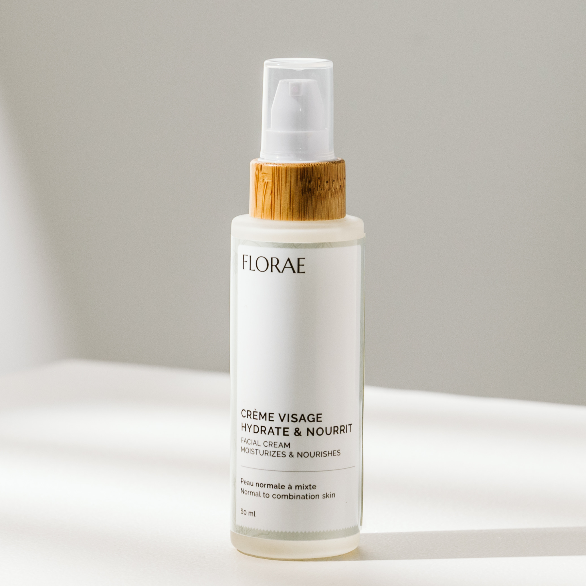 Crème hydratante naturelle de la gamme Florae cosmétique, dans un flacon de verre avec un bouchon de bambou muni d&
