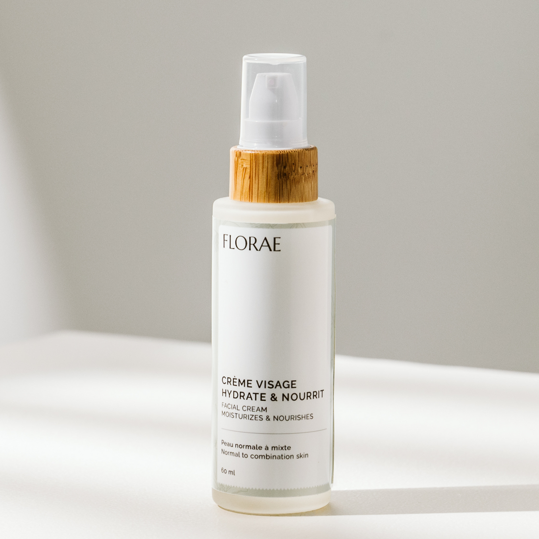 Crème hydratante naturelle de la gamme Florae cosmétique, dans un flacon de verre avec un bouchon de bambou muni d&